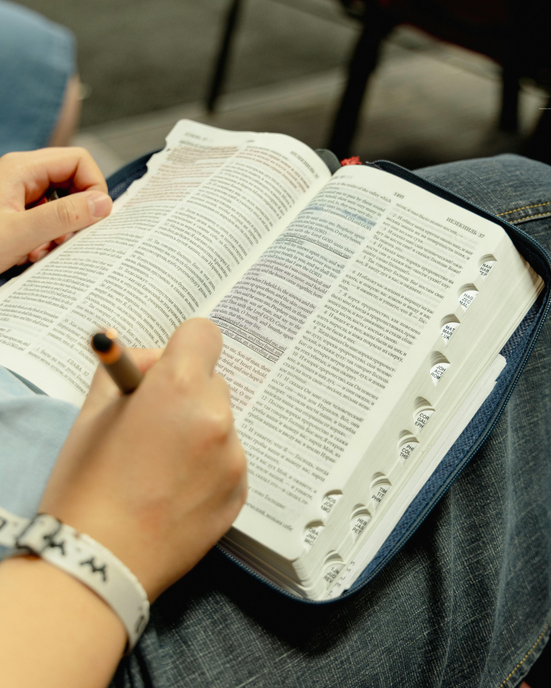 A woman looking down at a table with an open book. 